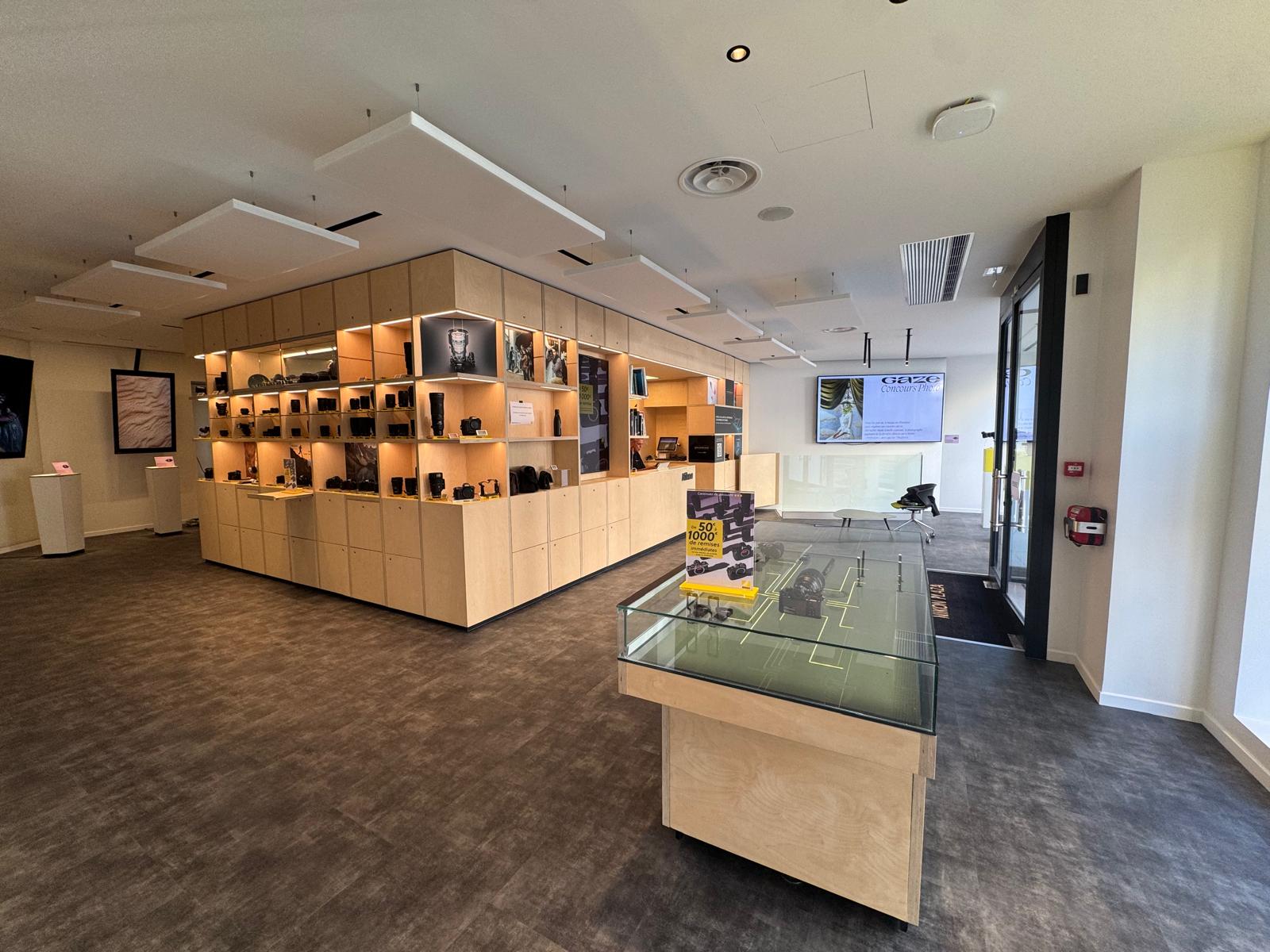 Nikon Pro showroom: birch-ply display island and back-lit shelving.